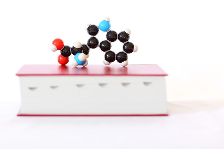 l-tryptophan molecular model on top of a red book